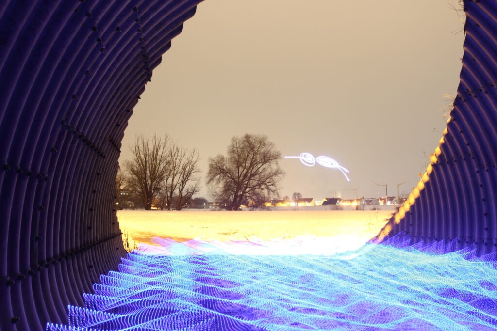 Abstrakte Lichtmalerei: Blick durch mit Wasser gefüllten Tunnel, erstellt durch Langzeitbelichtung.